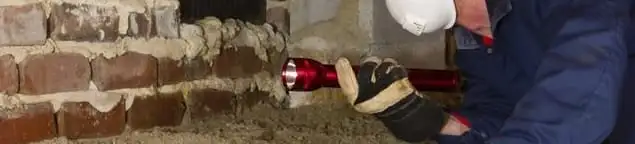 Pest control technician inspecting a crawl space for ant activity and entry points in Fort Worth, TX