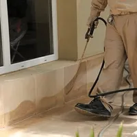 General pest control technician spraying exterior perimeter around a home in Fort Worth, TX